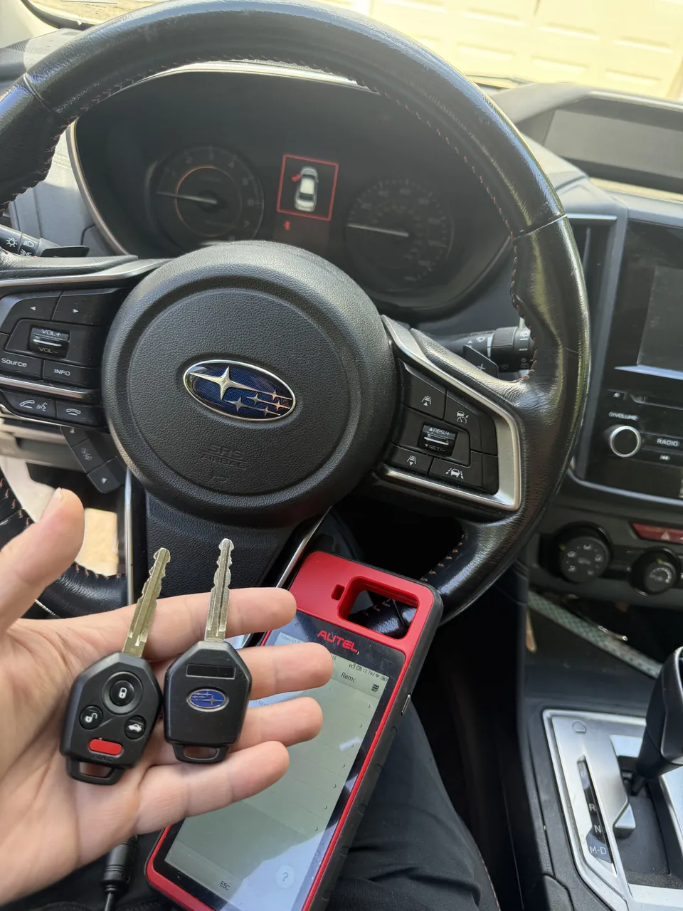 Vehicle key beside an automotive key programming device